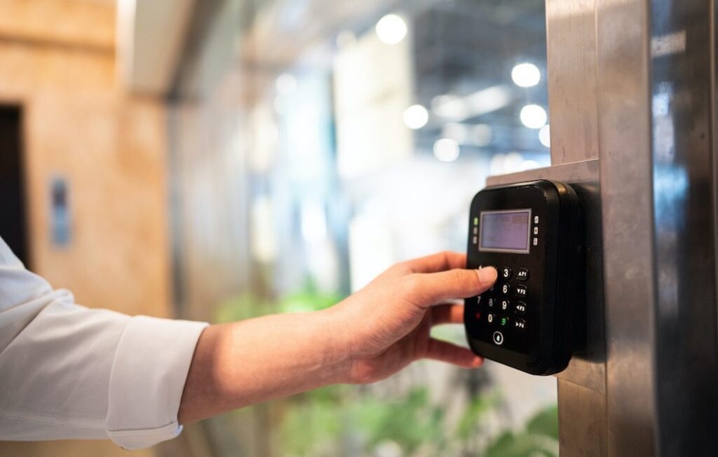 Unrecognizable person entering code at door